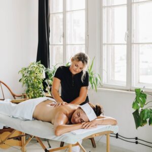 Photo of a Topless Woman Getting a Back Massage from a Masseuse